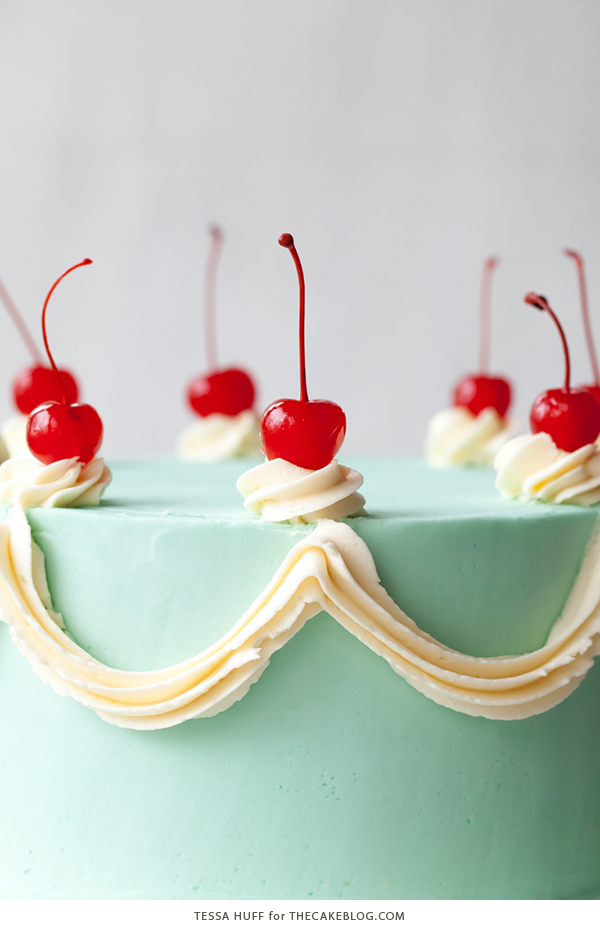 Cherry Chip Cake - maraschino cherry cake studded with chocolate chips, layered with chocolate ganache and finished with a whipped vanilla buttercream frosting | by Tessa Huff for TheCakeBlog.com