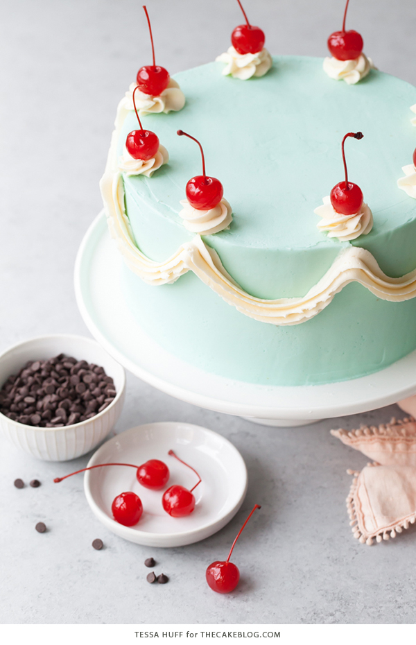 Cherry Chip Cake - maraschino cherry cake studded with chocolate chips, layered with chocolate ganache and finished with a whipped vanilla buttercream frosting | by Tessa Huff for TheCakeBlog.com