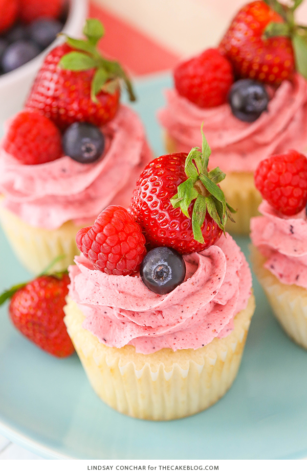 Berries and Cream Cupcakes - mixed berry buttercream paired with a moist vanilla cupcake stuffed with whipped cream cheese filling, topped with fresh strawberries, raspberries and blueberries | by Lindsay Conchar for TheCakeBlog.com